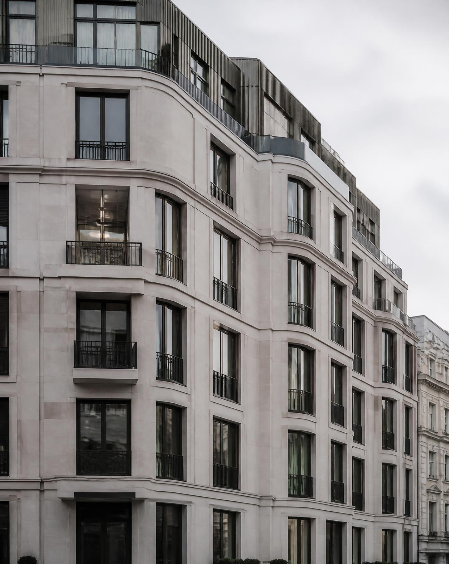 Contemporary London residential facade in pale stone and dark metal